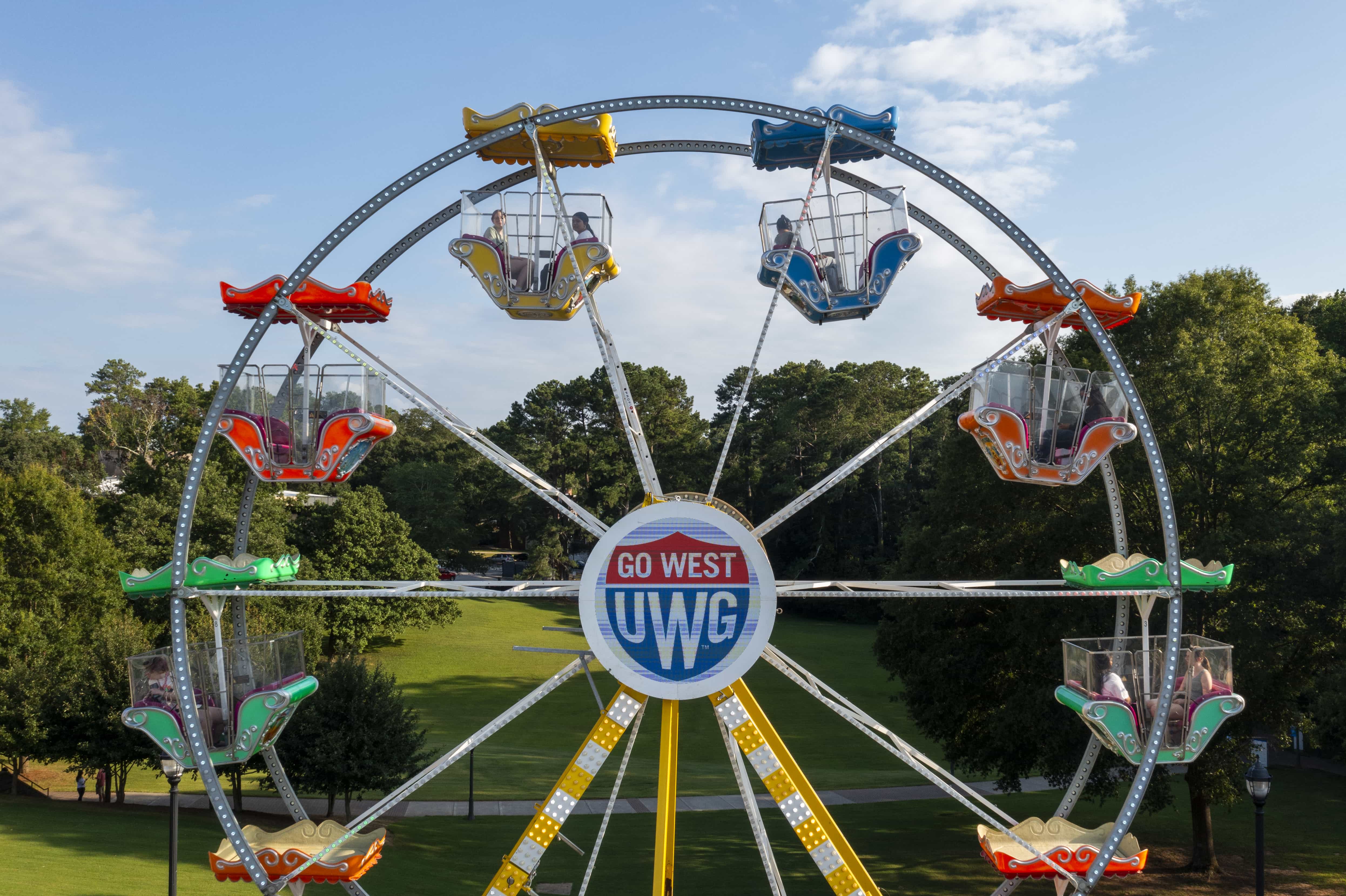 沙巴官网 branded ferris wheel with LED Shield logo lit up in the center, set up in Love Valley.