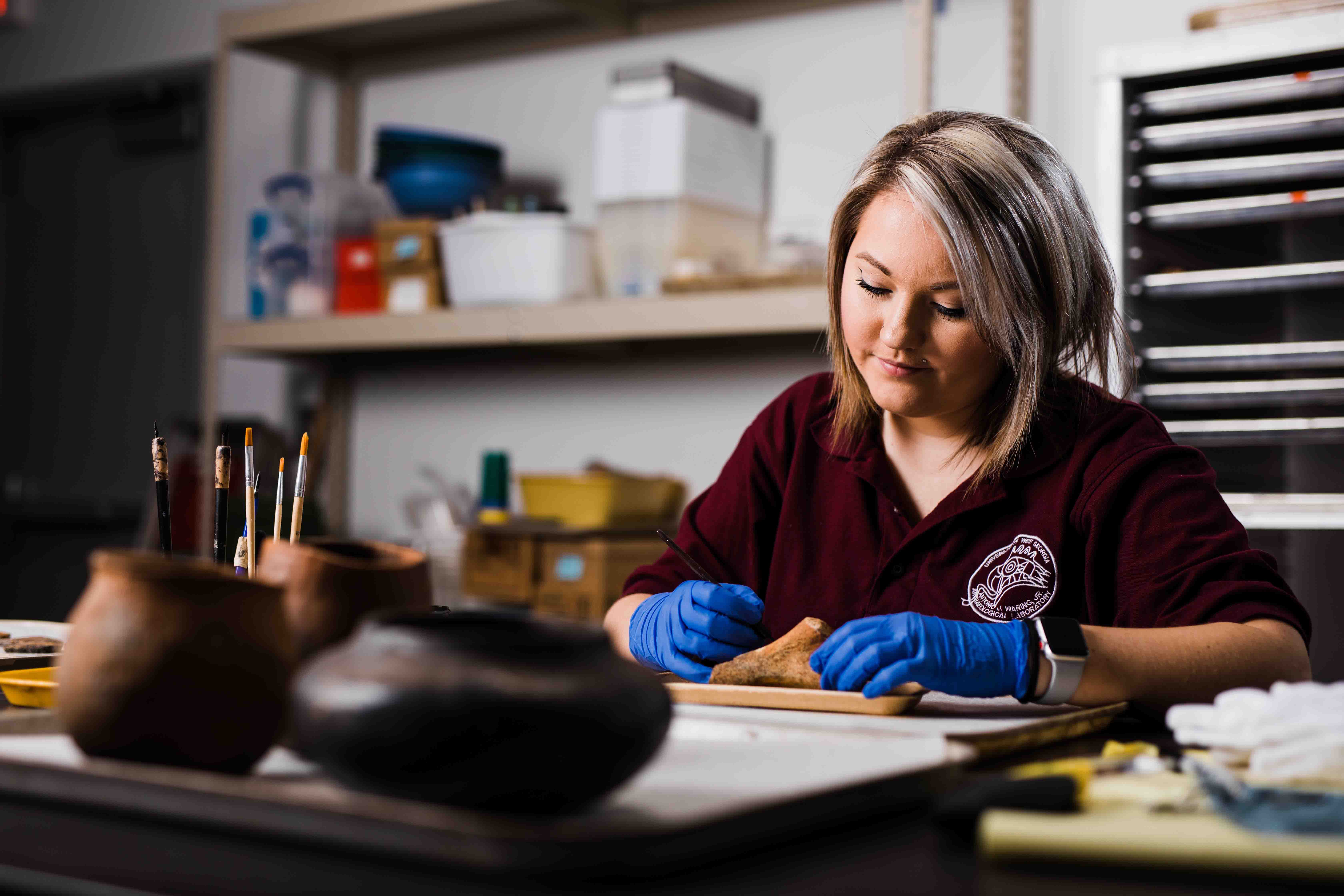 student studying a clay jar