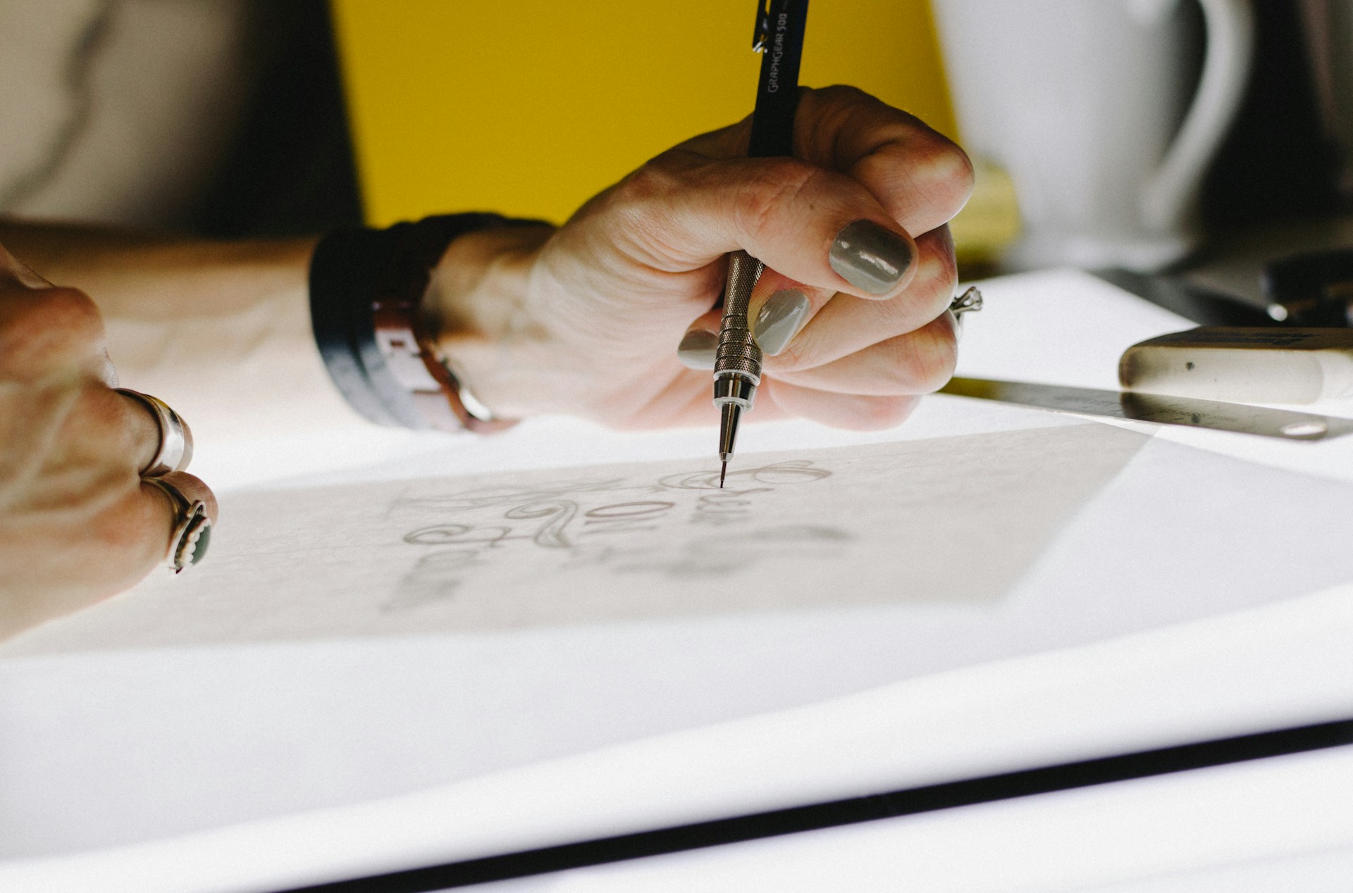 person sketching on a light box