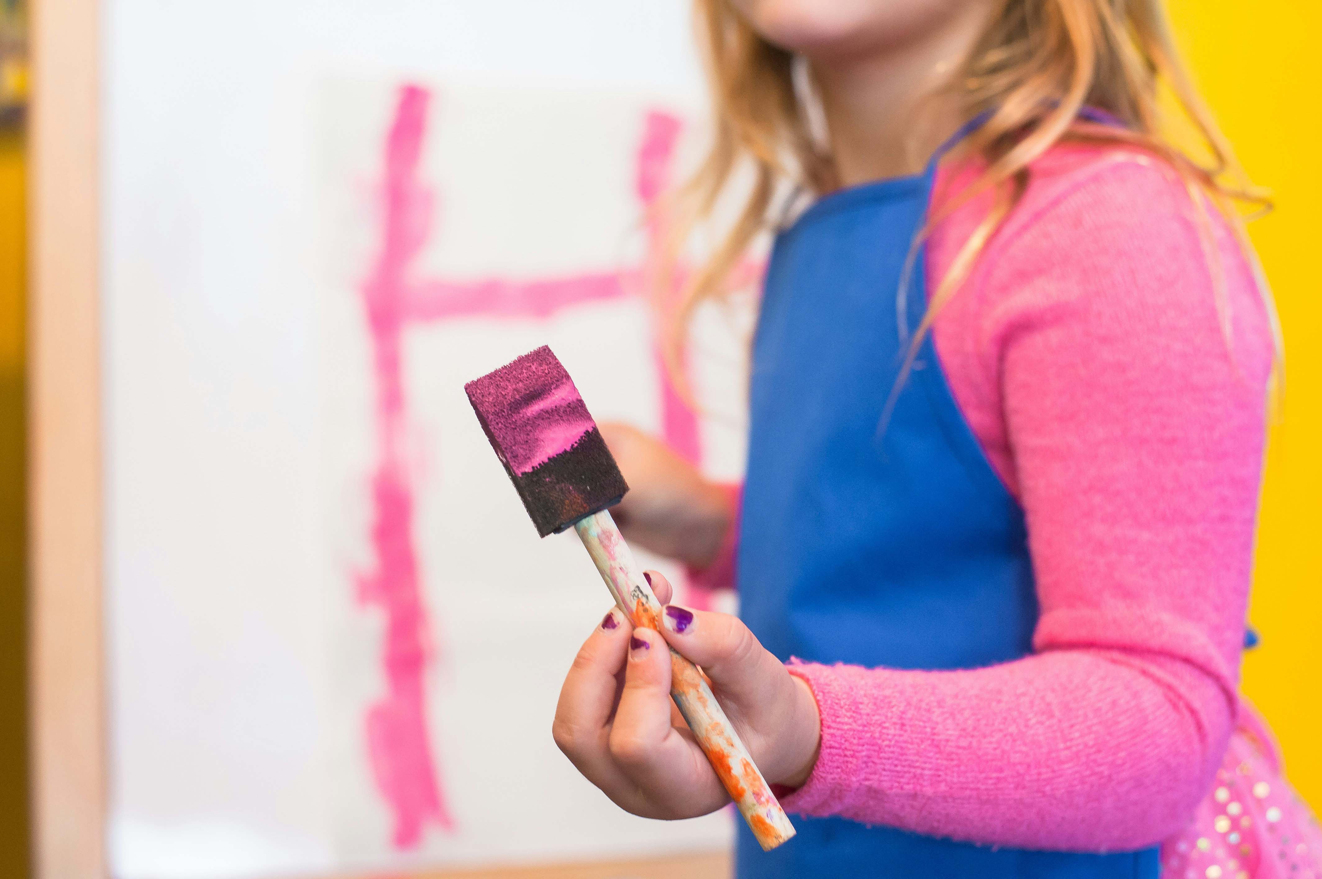 girl using pink paint brush
