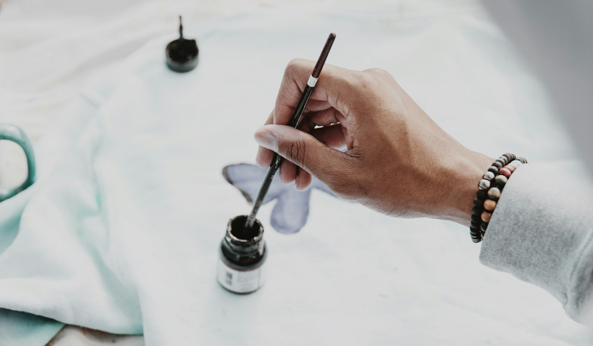 person holding pen and writing on paper