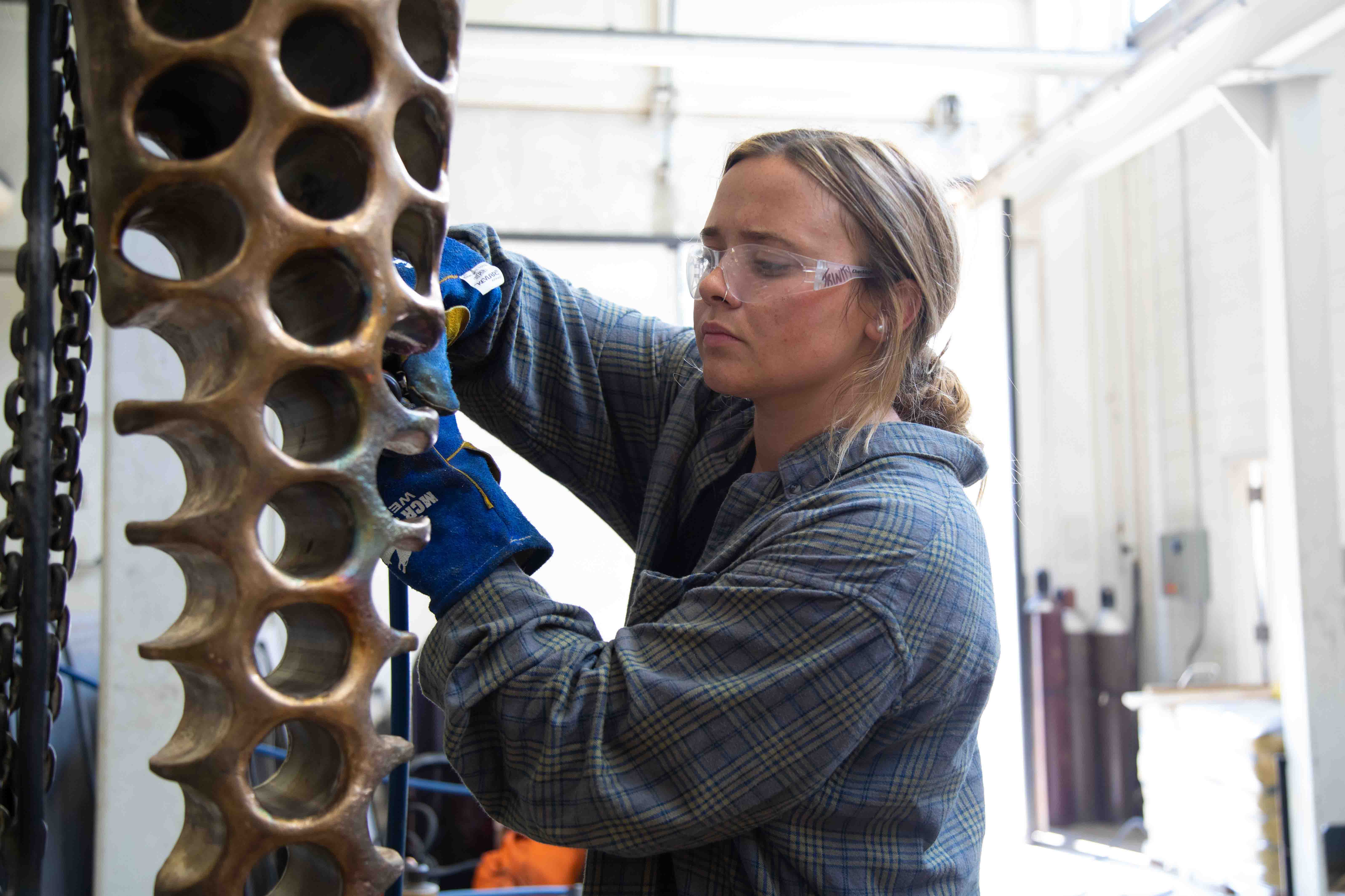 Trinity Dendy works on her sculpture "What It Isn't" at the Visual Arts Building