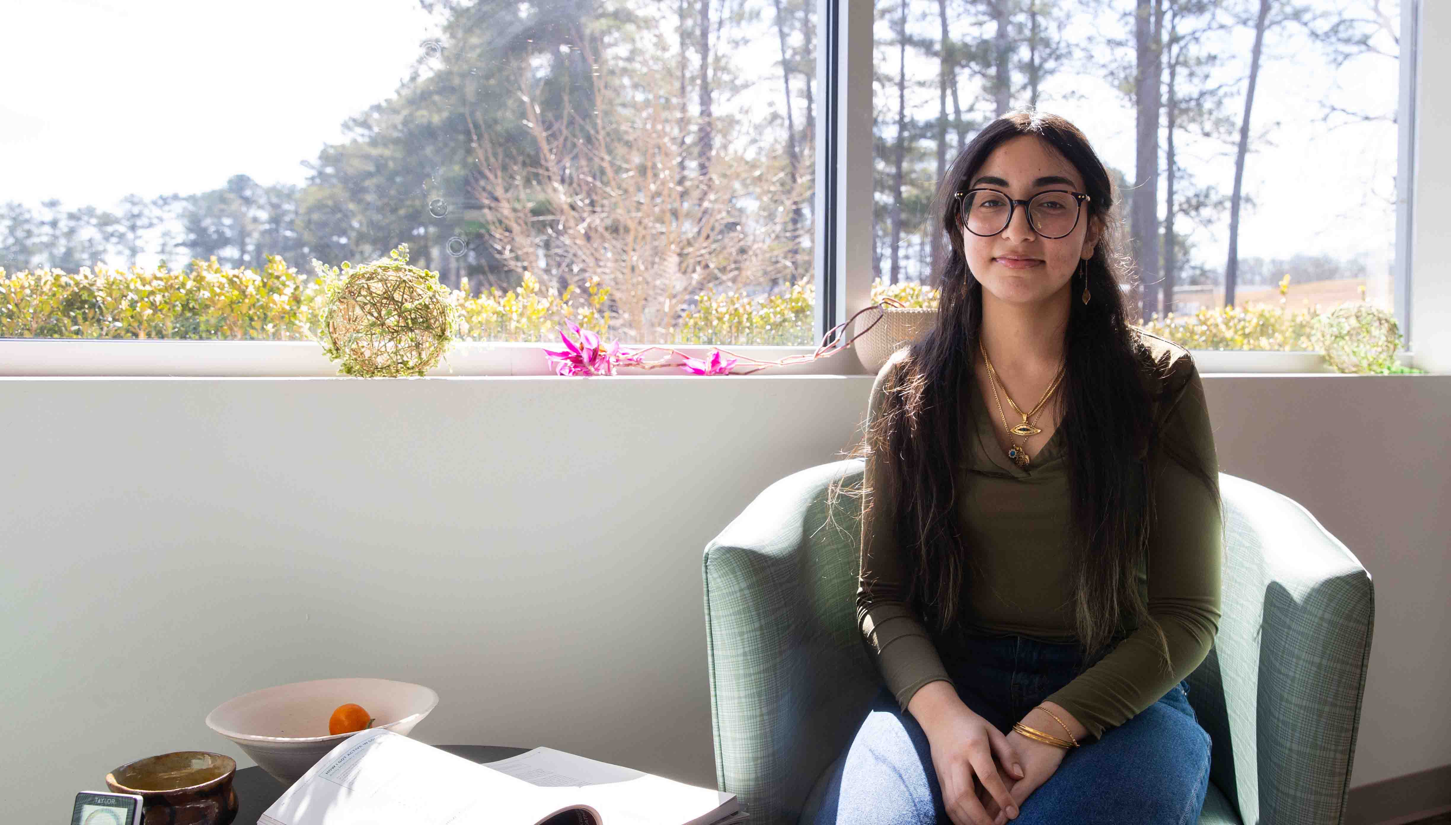 a female student sitting in front of a window