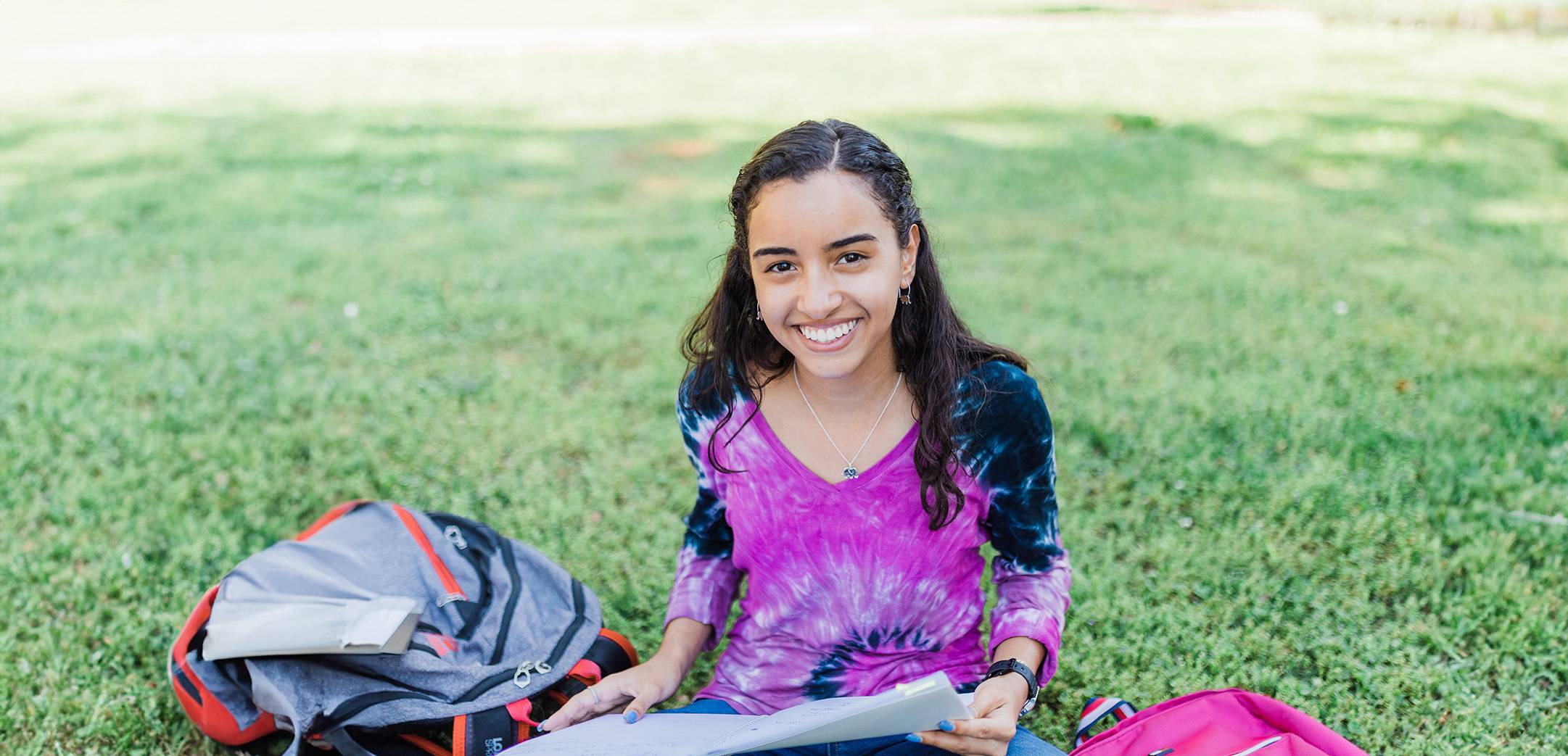 girl smiling seated on grass