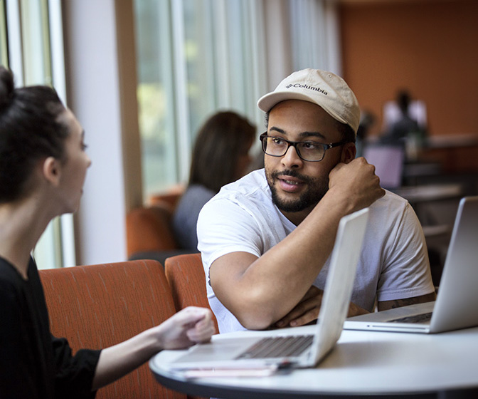 students talking with laptops at table