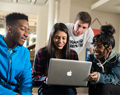 students gathered around a laptop