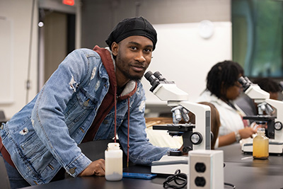 student with microscope