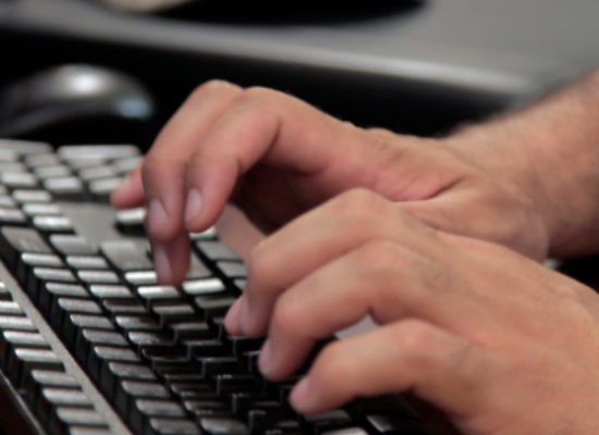 student typing on a keyboard