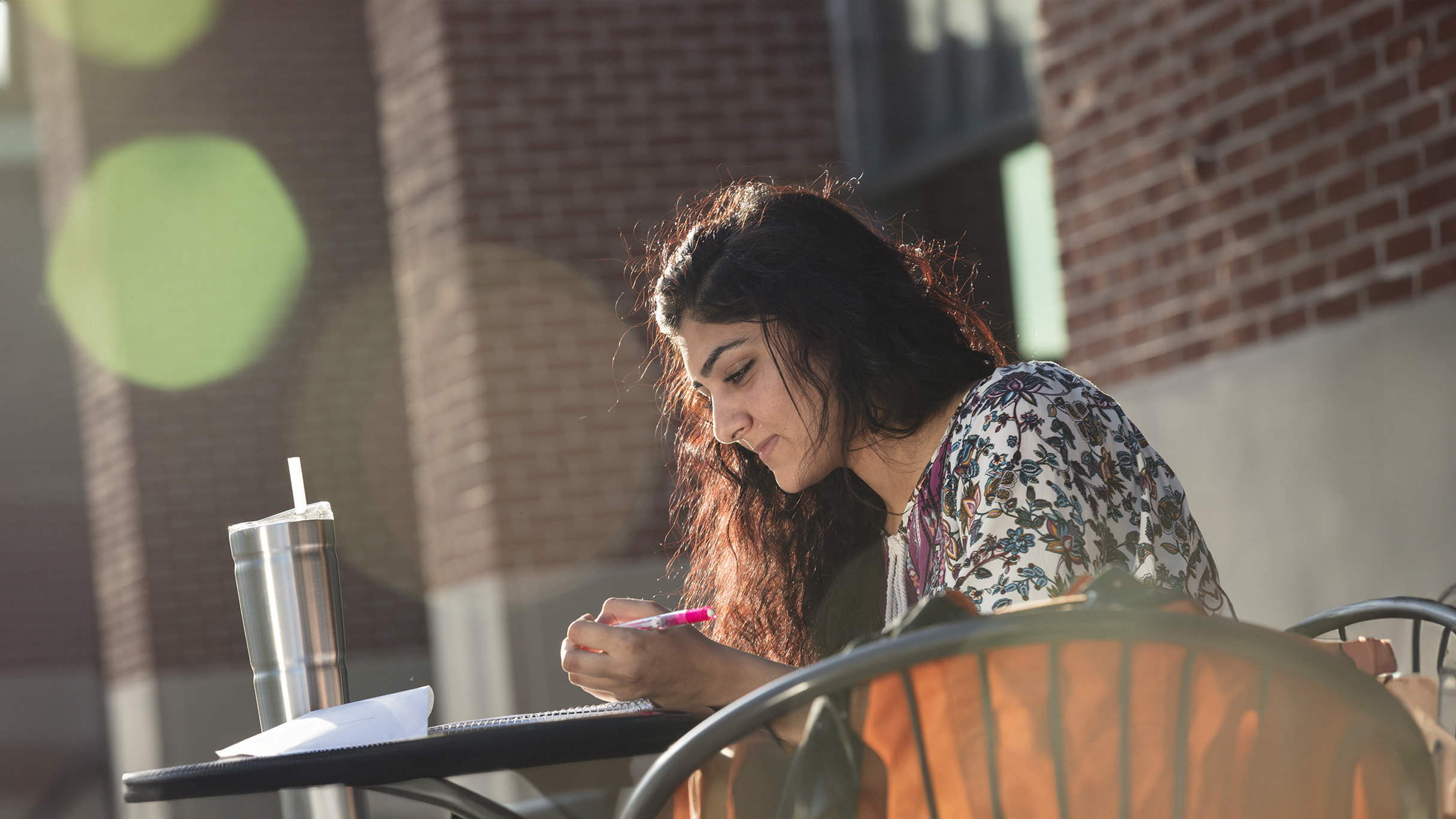 female student seated and writing