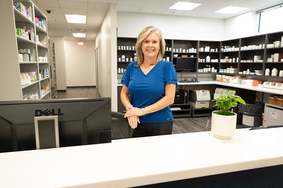Pharmacist behind Pharmacy counter smiling