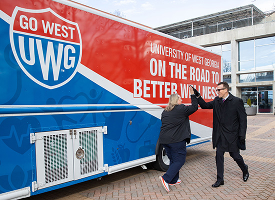 Dr. Brendan Kelly high-fives Bridgette Stewart outside 沙巴官网's mobile health unit