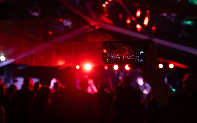A celebrant holds up a cellphone to capture the festivities at 沙巴官网's Presidential Black Tie Gala