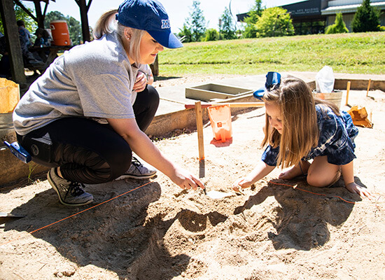 Child digs in a mock excavation pit