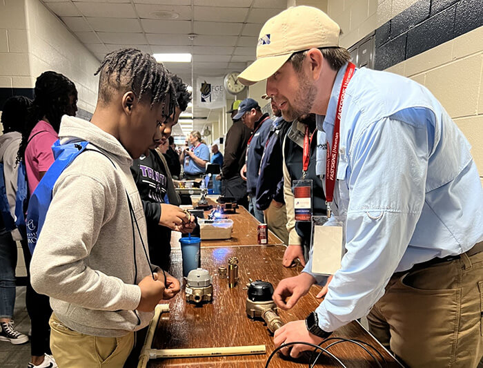 A Newnan Utilities employee speaking to students