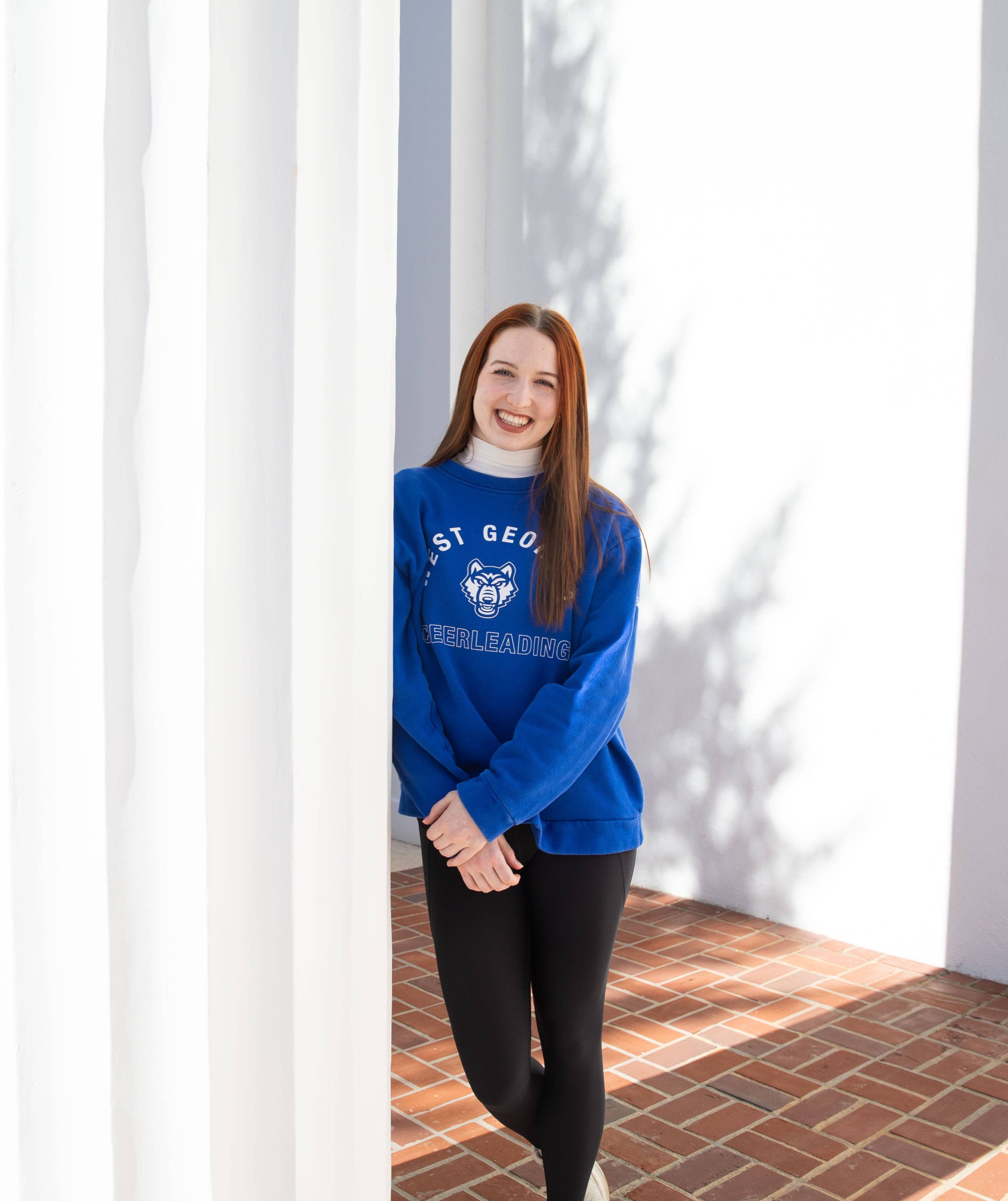Elora posing for outside for a portrait repping her 沙巴官网 gear.