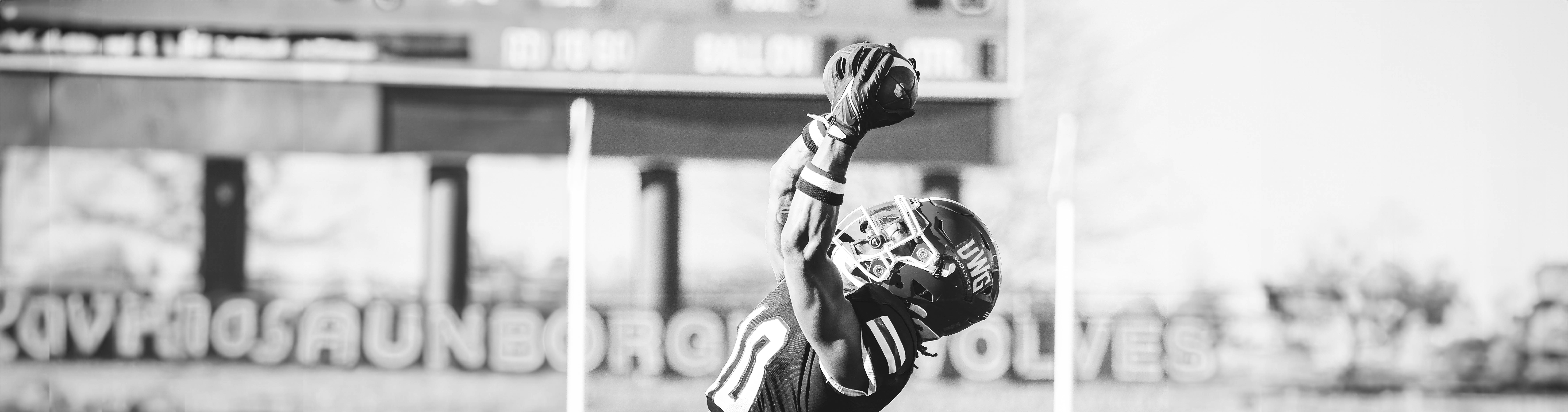 沙巴官网 Football Player jumping into the air to catch the football.
