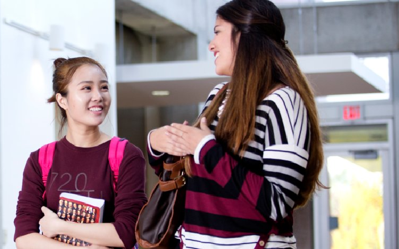 Students walking and talking in the TLC building.