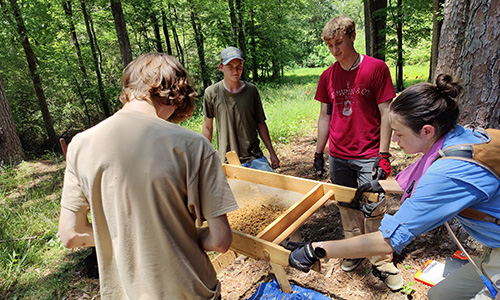 students sifting for artifacts