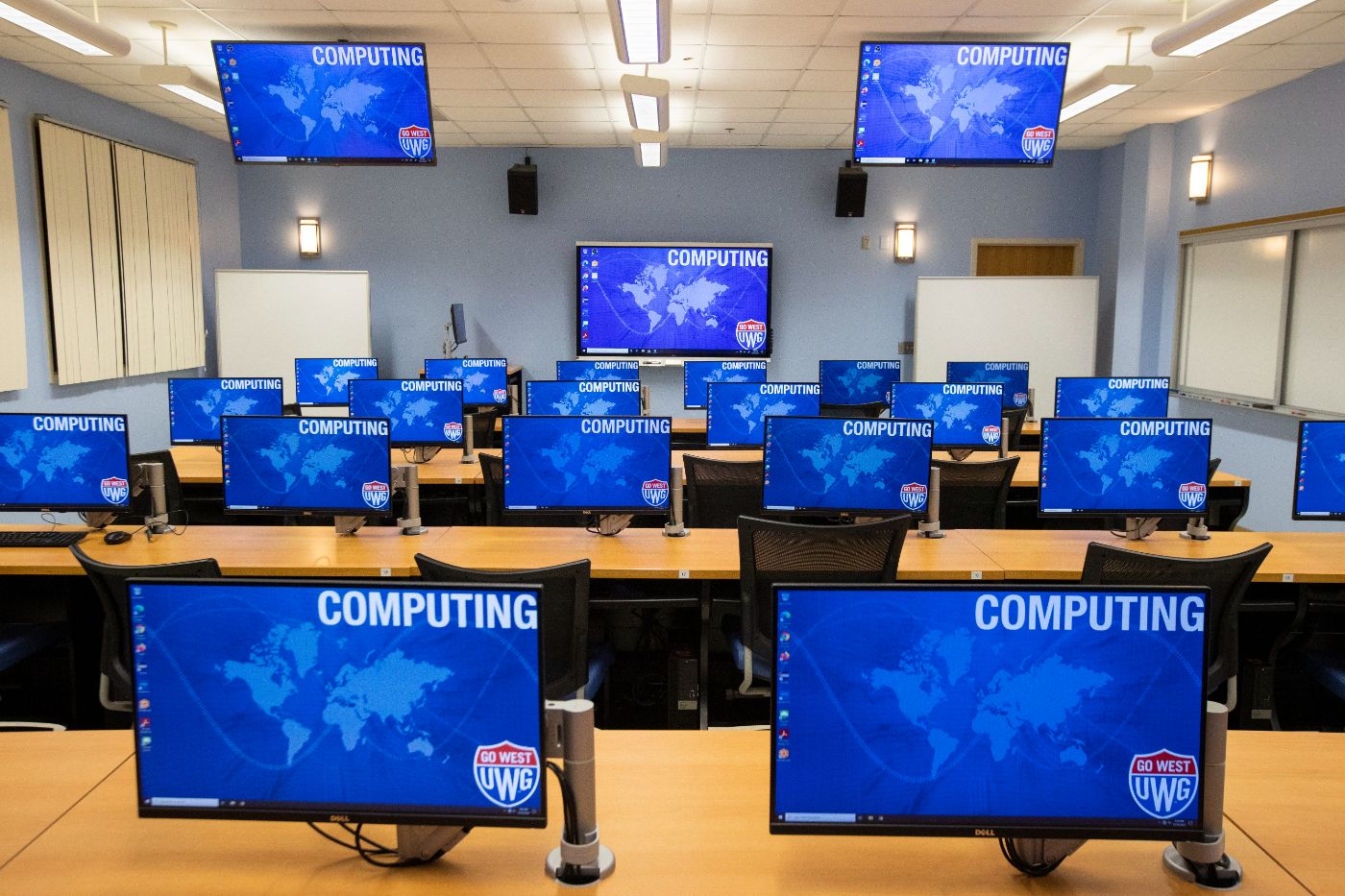 Empty computer lab with all computers turned on.